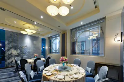 a room with tables and chairs and a large window at Miracle Grand Convention Hotel in Bangkok