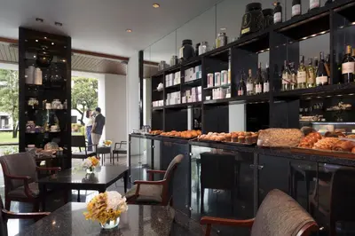 a restaurant with a bar with tables and bottles of wine at The Sukhothai Bangkok in Bangkok