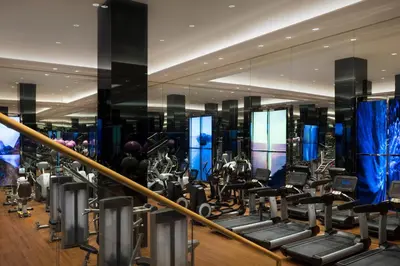 a gym with rows of exercise equipment in a building at The Sukhothai Bangkok in Bangkok