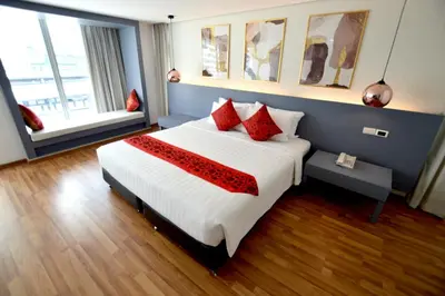 a bedroom with a large bed with red pillows at I Residence Hotel Silom in Bangkok