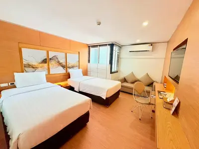 a hotel room with two beds and a couch at I Residence Hotel Silom in Bangkok