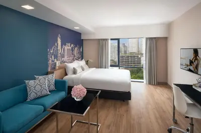 a hotel room with a bed and a couch at Citadines Sukhumvit 8 Bangkok in Bangkok
