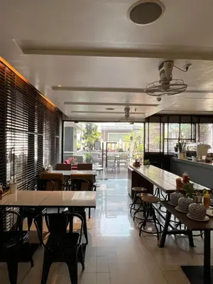 a dining room with tables and chairs and windows at Citadines Sukhumvit 8 Bangkok in Bangkok