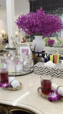 a table with purple flowers and a vase of purple flowers at Citadines Sukhumvit 8 Bangkok in Bangkok