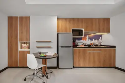 a kitchen with a small table and a refrigerator at Citadines Sukhumvit 11 Bangkok in Bangkok