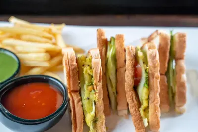 a white plate with a sandwich and french fries at Citadines Sukhumvit 11 Bangkok in Bangkok