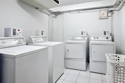 a white laundry room with white washer and dryer at Citadines Sukhumvit 11 Bangkok in Bangkok