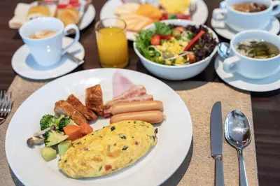 a table with plates of food and a plate of breakfast foods at Admiral Premier Bangkok in Bangkok