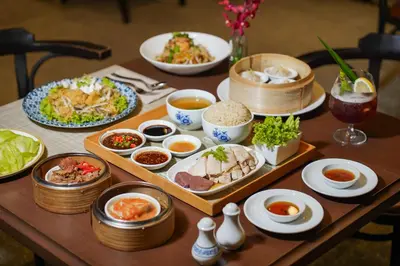 a table with plates of food and bowls of food at Montien Hotel Surawong Bangkok in Bangkok