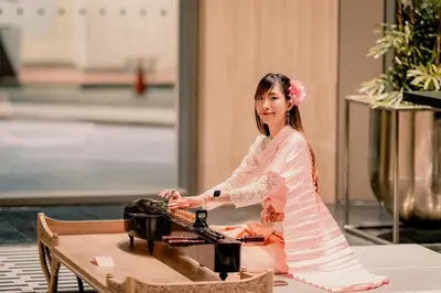 a woman in a dress sitting at a table at Montien Hotel Surawong Bangkok in Bangkok