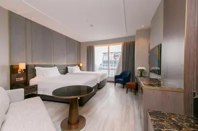 a hotel room with two beds and a couch at Centara Grand At CentralWorld in Bangkok
