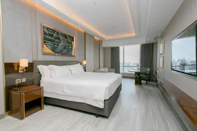 a hotel room with a bed and a large window at Centara Grand At CentralWorld in Bangkok