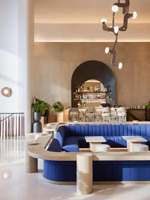 a lobby with a blue couch and a restaurant at Centara Grand At CentralWorld in Bangkok