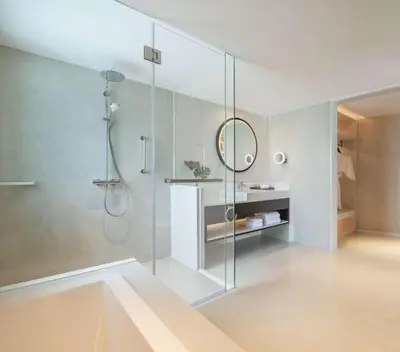 a bathroom with a shower with a glass shower stall at DoubleTree by Hilton Bangkok Ploenchit in Bangkok