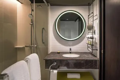a bathroom with a sink and a mirror at DoubleTree by Hilton Bangkok Ploenchit in Bangkok