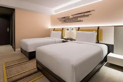 a hotel room with two beds and a hallway at DoubleTree by Hilton Bangkok Ploenchit in Bangkok