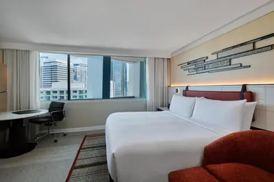 a hotel room with a bed and a chair and a window at DoubleTree by Hilton Bangkok Ploenchit in Bangkok