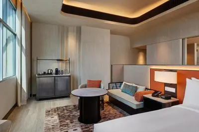 a hotel room with a bed and a couch and a table at DoubleTree by Hilton Bangkok Ploenchit in Bangkok