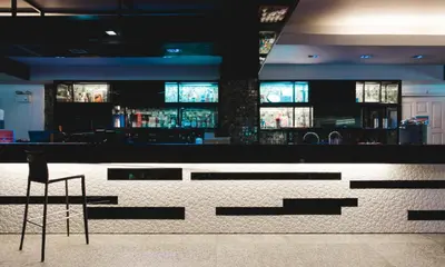 a bar in a restaurant with a chair in the foreground at Convenient Park Bangkok in Bangkok