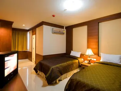 a hotel room with two beds and a flat screen tv at Convenient Park Bangkok in Bangkok
