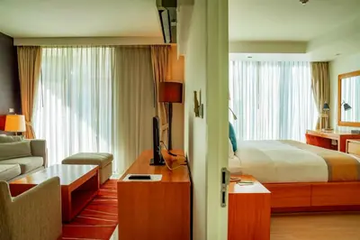 a hotel room with a bed and a living room at Oakwood Residence Sukhumvit 24 Bangkok in Bangkok