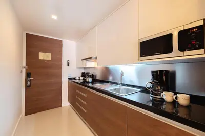a kitchen with a sink and a counter top at Oakwood Residence Sukhumvit 24 Bangkok in Bangkok