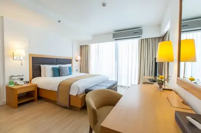 a hotel room with a bed and a desk at Oakwood Residence Sukhumvit 24 Bangkok in Bangkok