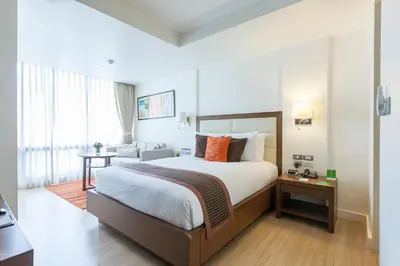 a hotel room with a bed and a couch at Oakwood Residence Sukhumvit 24 Bangkok in Bangkok
