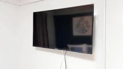 a flat screen tv hanging on a wall at Baan Pinklao in Bangkok