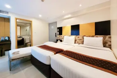 a hotel room with two beds and a bathroom at Citin Pratunam Bangkok by Compass Hospitality in Bangkok