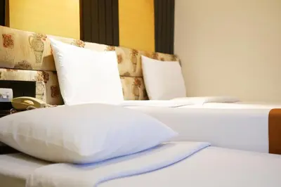 two beds with white pillows in a room at Citin Pratunam Bangkok by Compass Hospitality in Bangkok