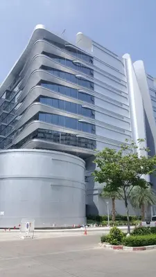 a large building with a tree in front of it at Popular Condo by Jintana in Pak Kret