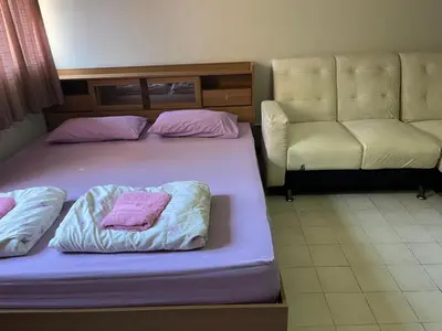 a bedroom with two beds and a couch at Popular Condo by Jintana in Pak Kret