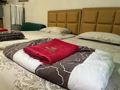 two beds with a red towel on top of them at Popular Condo by Jintana in Pak Kret