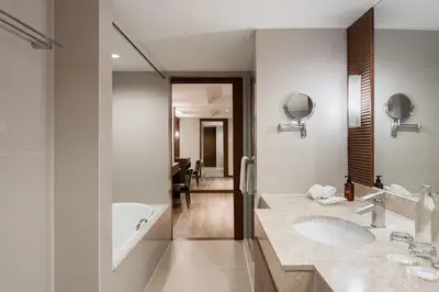 a bathroom with two sinks and a bath tub at Dusit Princess Srinakarin Bangkok in Bangkok
