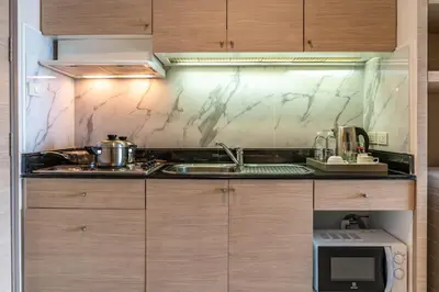 a kitchen with a sink and a microwave at Jasmine City Hotel in Bangkok