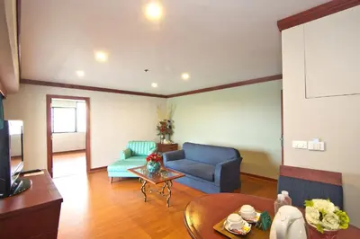 a living room with a couch and a table at Baiyoke Suite Hotel in Bangkok