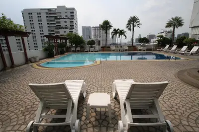 a swimming pool with lounge chairs and a hotel at Baiyoke Suite Hotel in Bangkok