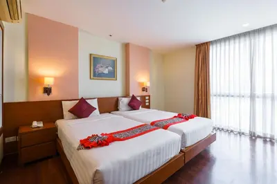 a bedroom with a large bed with red flowers on it at Lantana Resort Hotel Bangkok in Bangkok