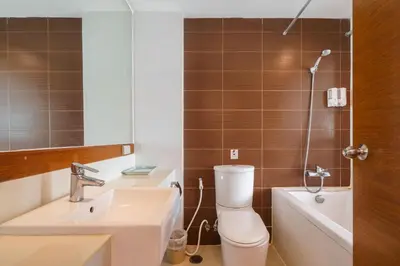 a bathroom with a toilet and a sink and a bath tub at Lantana Resort Hotel Bangkok in Bangkok