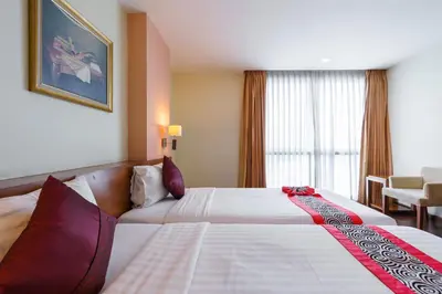 a hotel room with a large bed and a window at Lantana Resort Hotel Bangkok in Bangkok
