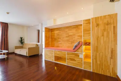 a living room with a large wooden wall at Lantana Resort Hotel Bangkok in Bangkok