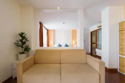 a living room with a couch and a mirror at Lantana Resort Hotel Bangkok in Bangkok