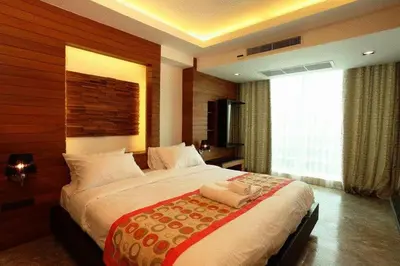 a bedroom with a large bed and a large window at Baannueng at Aree 5 Hotel in Bangkok