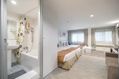 a bedroom with a bed and a tub and a sink at Pratunam City Inn in Bangkok