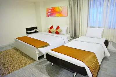 a hotel room with two beds and a window at Pratunam City Inn in Bangkok