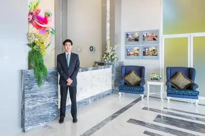 a man in a suit standing in a lobby at Pratunam City Inn in Bangkok
