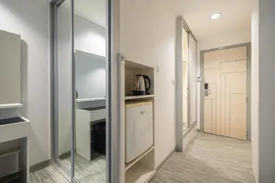 a kitchen with a glass door leading to a hallway at Pratunam City Inn in Bangkok