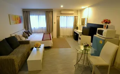 a living room with a bed and a couch in a room at Pratunam City Inn in Bangkok