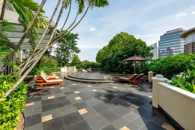 a courtyard with lounge chairs and a fountain at Conrad Bangkok in Bangkok